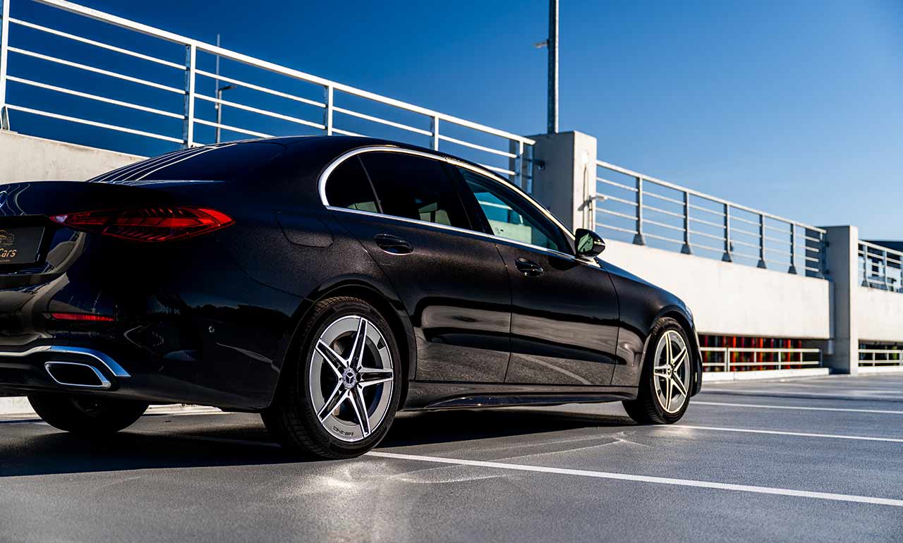 Luksusowy czarny Mercedes C-klasa 200D na parkingu dachowym