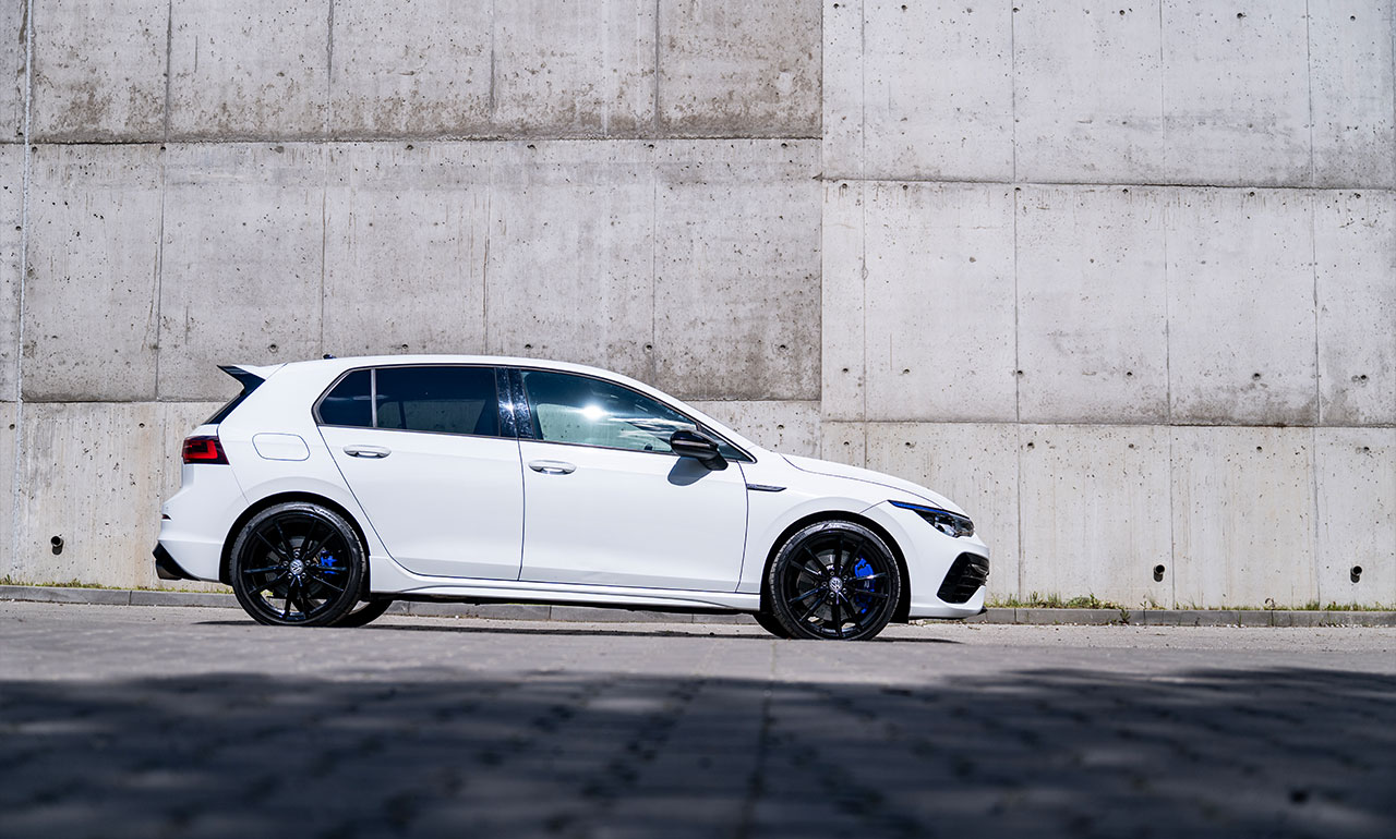 Biały Volkswagen Golf 8R z profilu na tle graffity