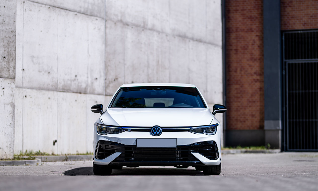 Biały Volkswagen Golf 8R od tyłu w nocnej scenerii wypożyczalnia Dedicars