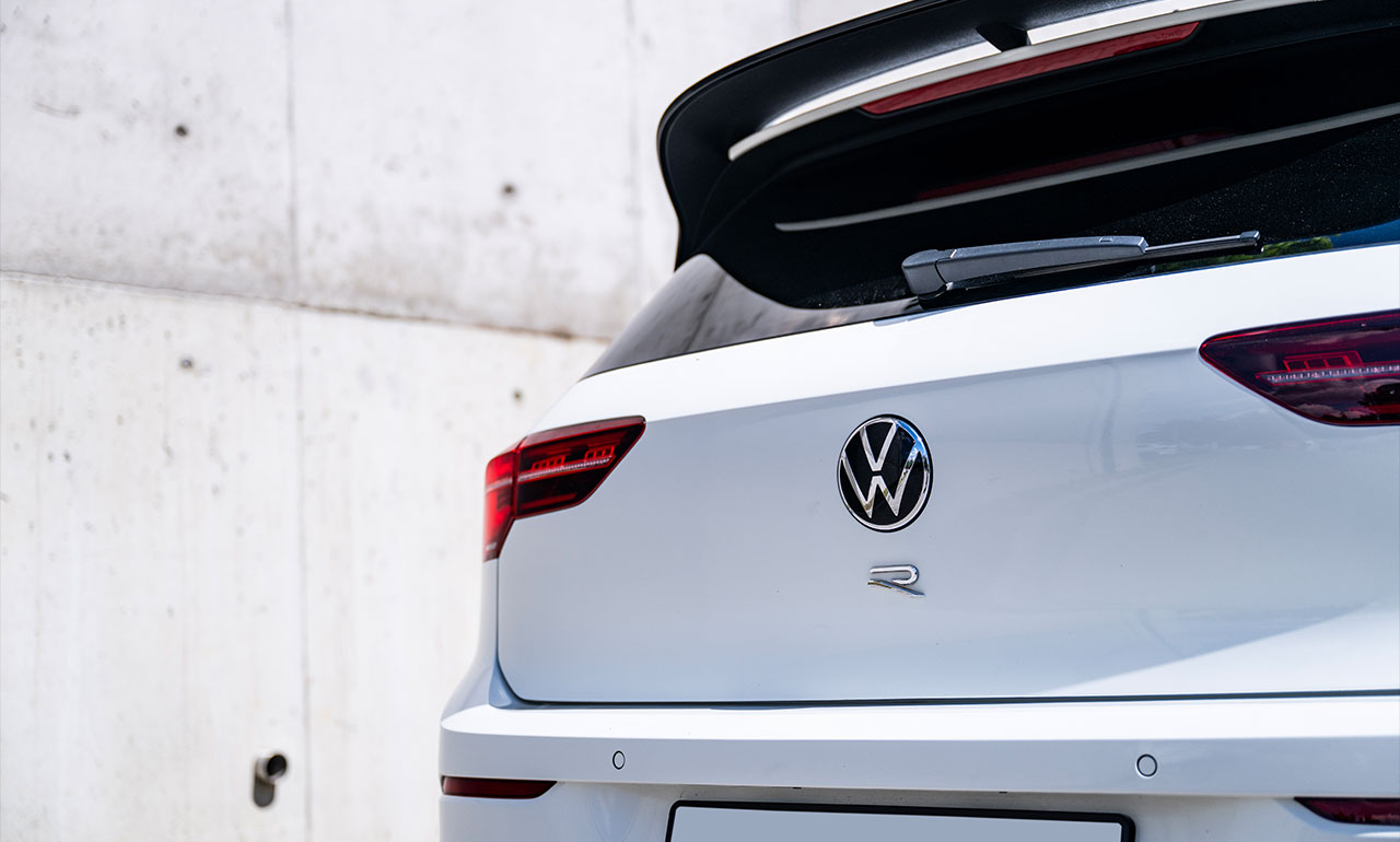 Volkswagen Golf 8R w kolorze białym na tle neonów nocą na wynajem w dedicars
